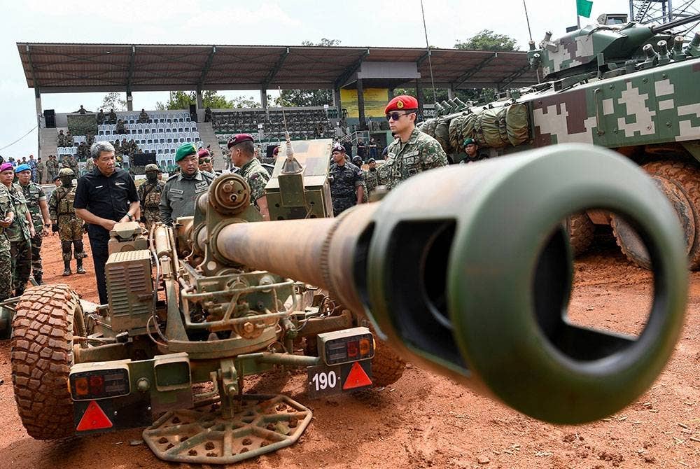 Al-Sultan Abdullah berkenan mendengar penerangan daripada seorang pegawai tentera mengenai meriam jenis 105mm LG1 MK III selepas menyaksikan pertunjukan Latihan Kuasa Tembakan 2023 di Lapang Sasar Kem Syed Sirajuddin pada Selasa. - Foto: Bernama