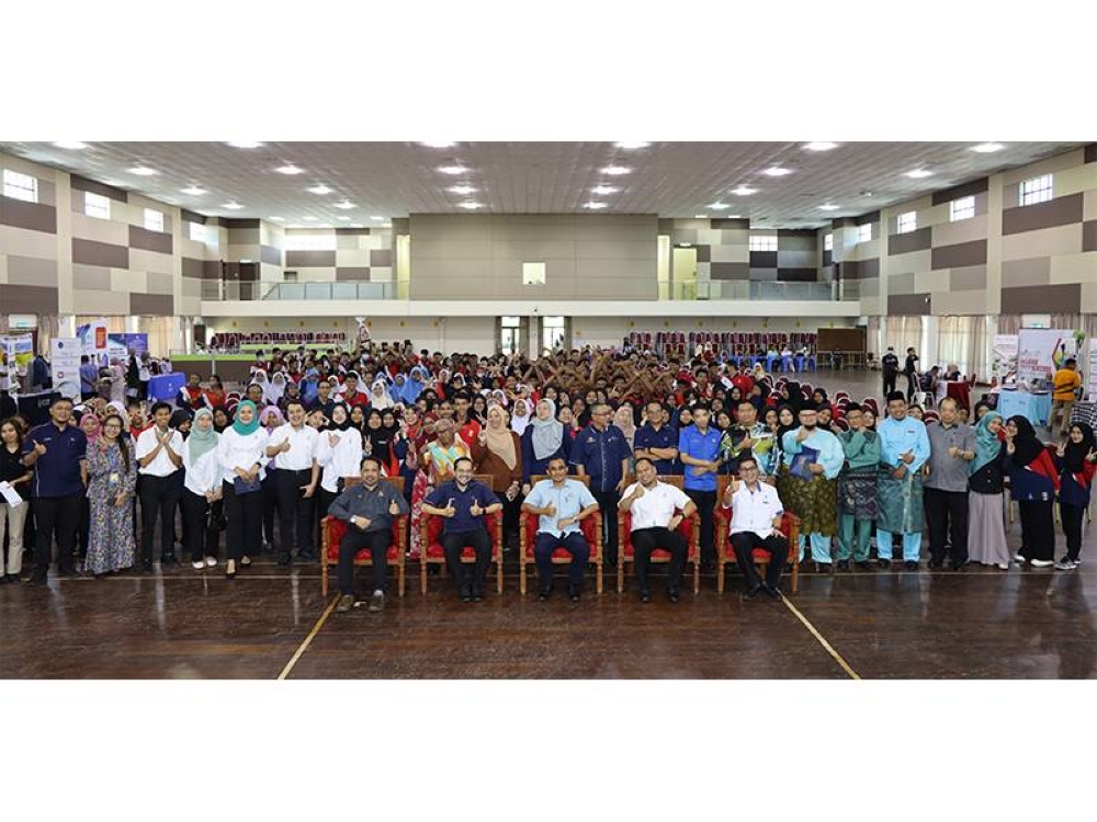 Norman (duduk, tengah) bergambar bersama pelajar SPM sekitar di Mersing dan pempamer.