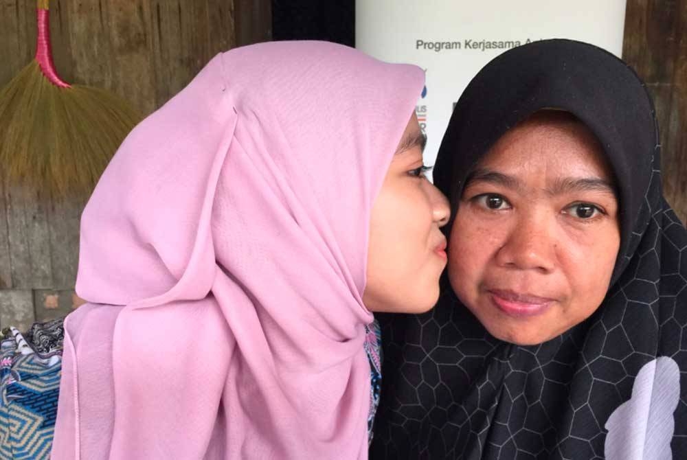 Fatin Nur Aqilah (kiri) yang gembira dan mencium pipi Moraini (kanan).