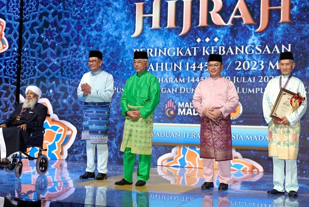 Al-Sultan Abdullah (tengah) berkenan bergambar bersama Abdul Monir (kanan) dan Sheikh Abubakr (kiri) pada Majlis Sambutan Ma'al Hijrah Peringkat Kebangsaan Tahun 1445H di Pusat Dagangan Dunia Kuala Lumpur (WTCKL) hari ini. - Foto Bernama