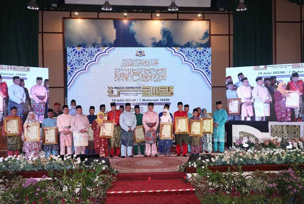 Rahmad dan Mohd Ali (tengah) bergambar bersama sebahagian penerima anugerah Tokoh Maal Hijrah sempena Sambutan Maal Hijrah 1445H peringkat negeri di Auditorium Al- Azim di Bukit Palah di sini, pada Rabu.