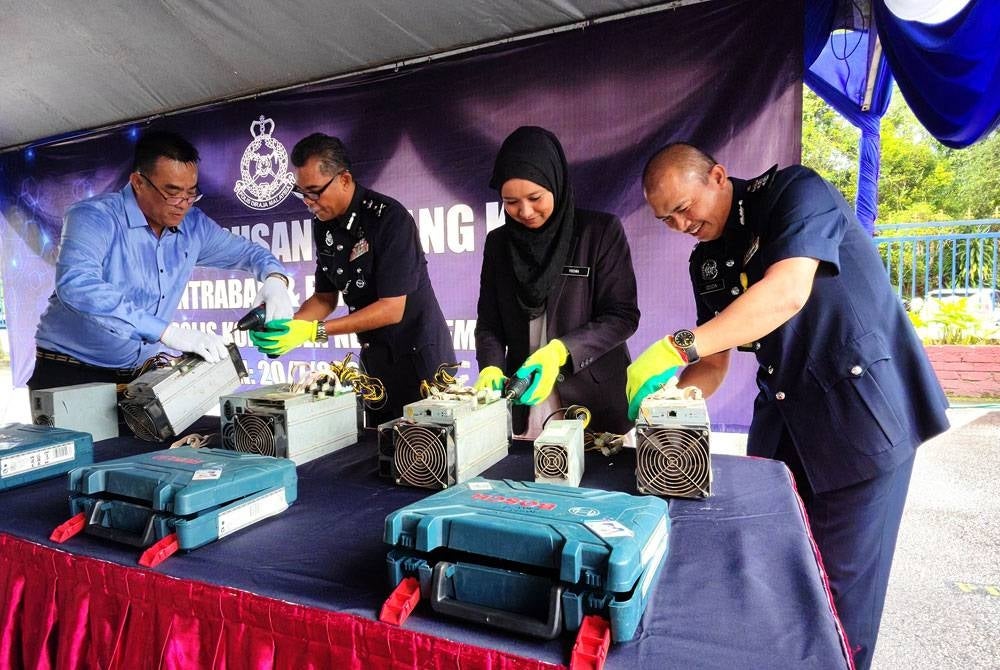 Abd Khalid (dua dari kiri) melupuskan mesin bitcoin di IPK Negeri Sembilan pada Khamis.