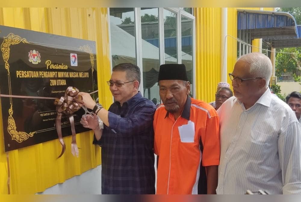 Salahuddin ( kiri) merasmikan Persatuan Pengampit Minyak Masak Melayu Zon Utara dan Langkawi Borong Edar di Alor Senjaya, Alor Setar pada Jumaat.