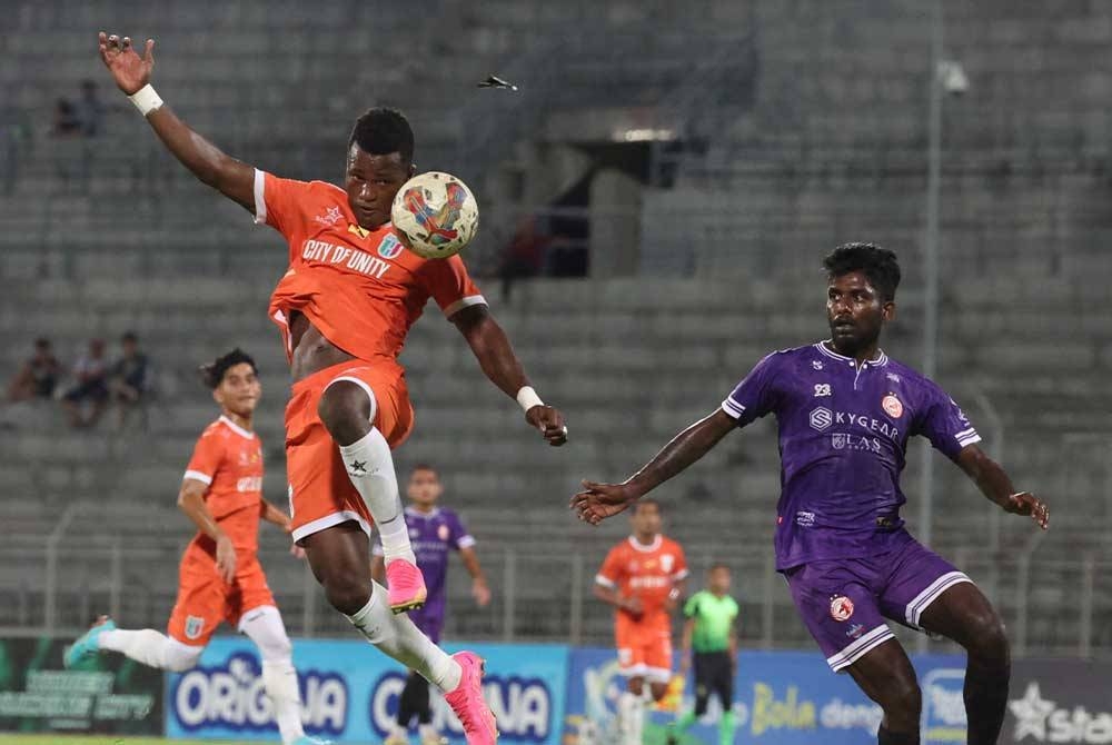 Pemain Kuching City, Abu Kamara (kiri) mengawal bola pada saingan Liga Super di Stadium Negeri pada Jumaat.