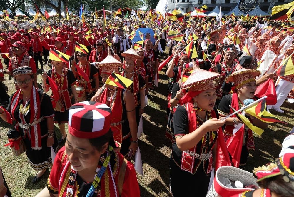 Peserta dari etnik Bidayuh Sarawak mengibarkan bendera negeri pada Perhimpunan dan Perarakan Sambutan 60 Tahun Sarawak Merdeka di Padang Merdeka, hari ini. - Foto Bernama