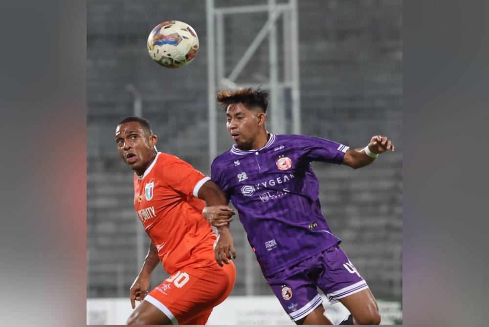 Pemain muda Kelantan, Mohd Rizaqmi Aktha Hashim mengasak tonggak Kuching City, Pedro Henrique (kiri) semasa saingan Liga Super di Stadium Negeri, Kuching.