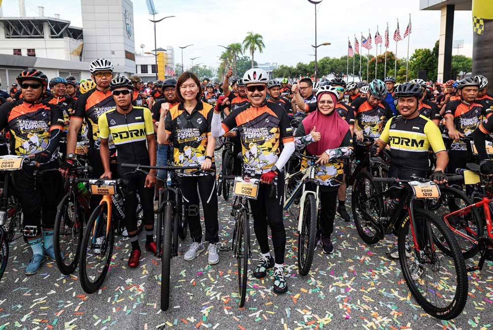 Mohd Yusri (tengah) bersama sebahagian peserta yang menyertai pelepasan Program Kayuhan Mega Perpaduan PDRM Perak pada Ahad.