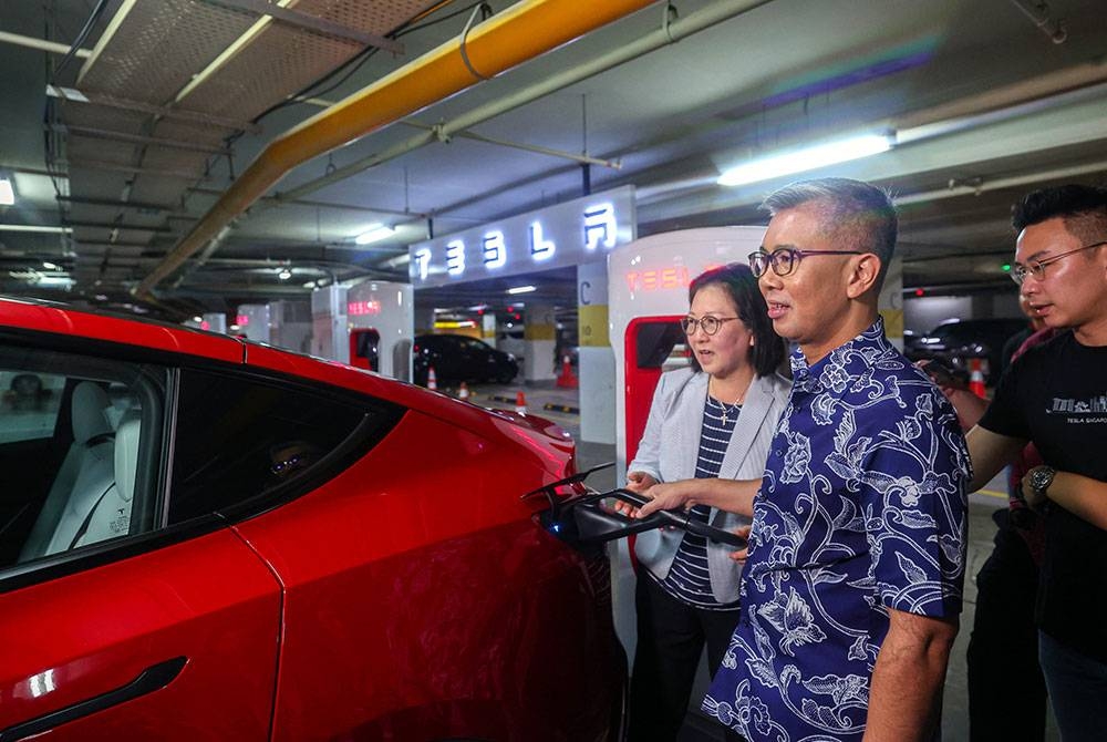 Menteri Pelaburan, Perdagangan dan Industri Tengku Datuk Seri Zafrul Tengku Abdul Aziz mencuba menggunakan Tesla Supercharger yang diletakkan di ruang parkir pusat membeli-belah Pavilion Kuala Lumpur baru-baru ini. - Foto Bernama