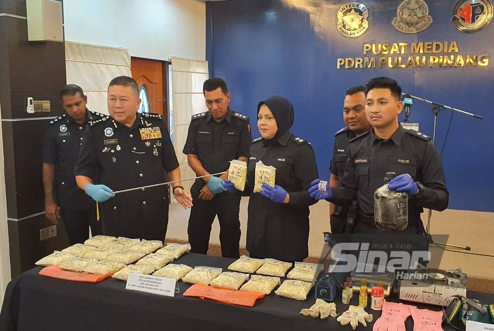 Kok Chin (kiri) menunjukkan dadah jenis heroin yang dirampas daripada dua suspek.