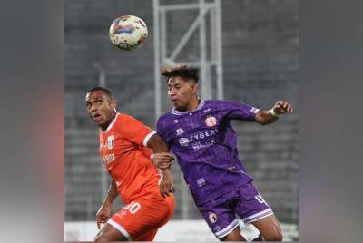 Pemain muda Kelantan, Mohd Rizaqmi Aktha Hashim mengasak tonggak Kuching City, Pedro Henrique (kiri) semasa saingan Liga Super di Stadium Negeri, Kuching.