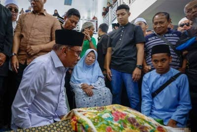 Anwar memberi penghormatan terakhir sebelum mengimamkan solat jenazah Salahuddin di Masjid Jamek Dato' Haji Noh Gadot, Serkat, Pontian pada Isnin. - Foto: Bernama