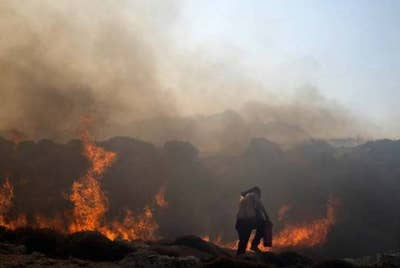 Seorang lelaki cuba memadamkan kebakaran yang tercetus di Lindos, Greece. - Foto AP