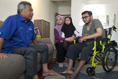 Ahmad mengunjungi Azlan (berkerusi roda) dan isterinya, Norhaspida di kediaman mereka di Pangsapuri Ladang Tok Pelam pada Selasa.