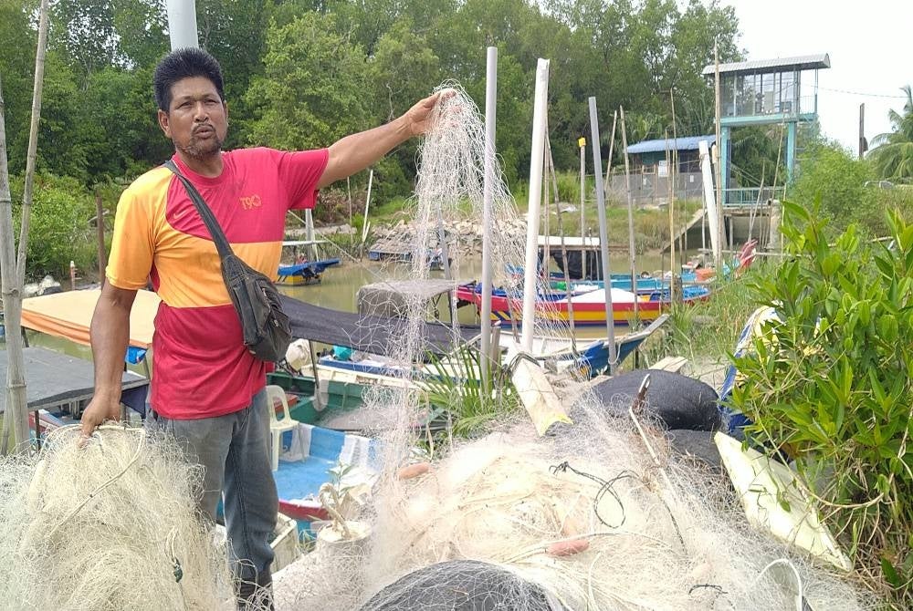 Jamil menunjukkan jaring nelayan tempatan yang dirosakkan oleh warga asing di perairan Bagan Datuk.