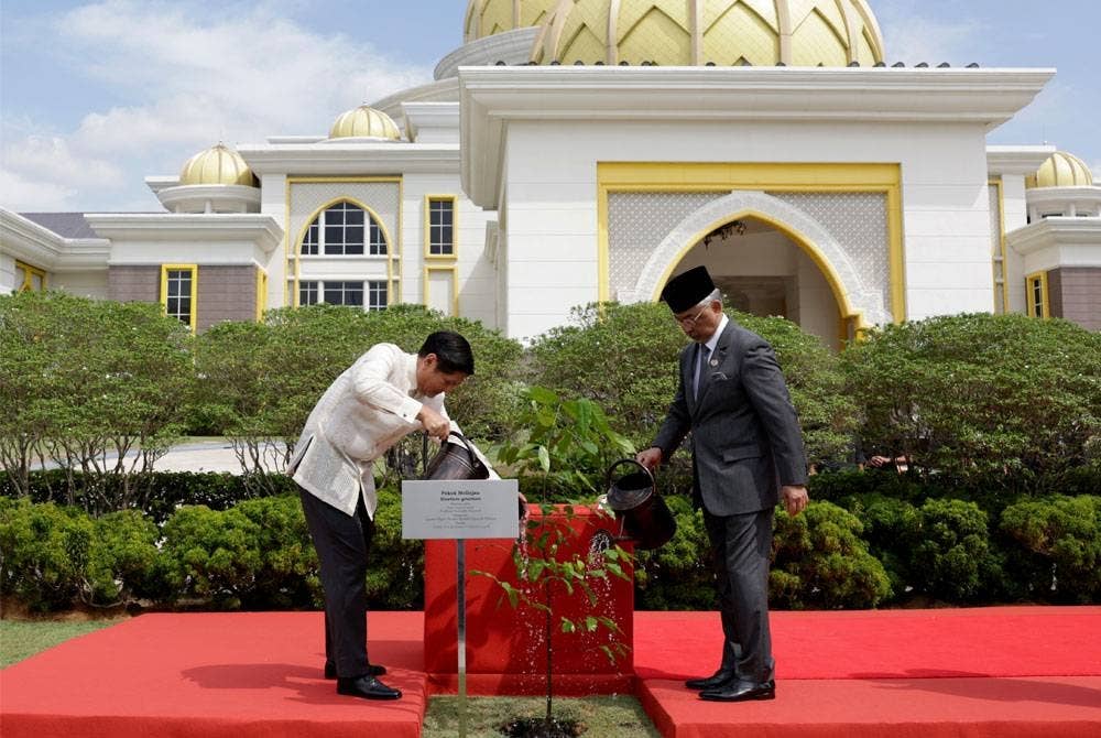 Al-Sultan Abdullah (kanan) berkenan menyaksikan upacara penanaman pokok Melinjau yang disempurnakan Ferdinand Marcos Jr di pekarangan Istana Negara hari ini. - Foto Bernama