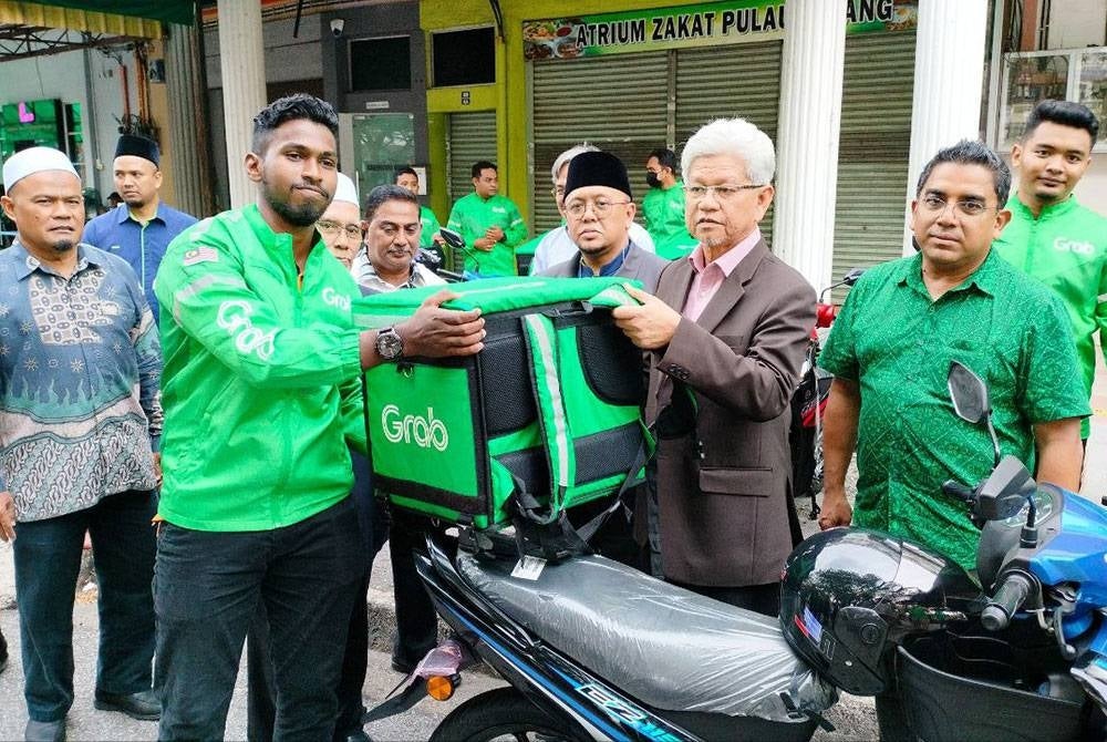 Ahmad Zakiyuddin (tiga dari kanan) menyerahkan peralatan kelengkapan untuk penghantar makanan kepada salah seorang peserta.