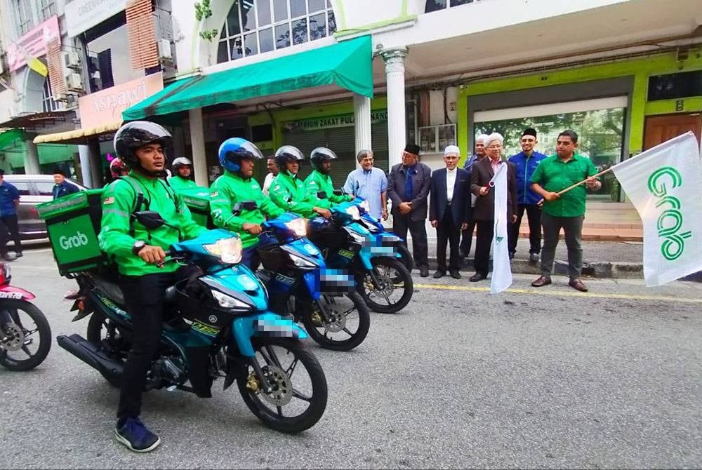 Ahmad Zakiyuddin (tiga dari kanan) melakukan gimik pelepasan sempena pelancaran Program RakanGrab Zakat Pulau Pinang di Bandar Perda pada Rabu.