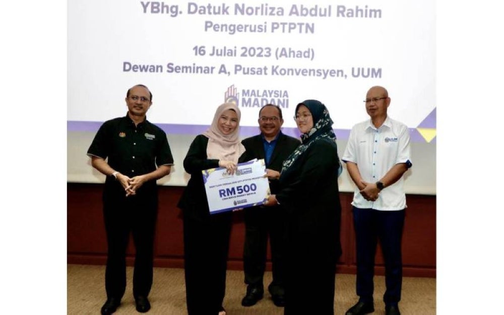 Norliza (dua dari kiri) menyerahkan sumbangan Bantuan Pengajian KPT-PTPTN Prihatin kepada salah seorang pelajar di UUM.