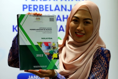 Penjawat Awam Tengku Mazlin Tengku Ab Hamid menunjukkan buku laporan Survei Perbelanjaan Isi Rumah 2022 pada Majlis Pengumuman Penemuan Survei Pendapatan dan Perbelanjaan Isi Rumah 2022 di Jabatan Perangkaan Malaysia hari ini. - Foto Bernama