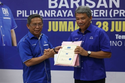 Mohamad (kanan) menyerahkan watikah kepada bakal calon DUN Pertang, Datuk Seri Jalaluddin Alias pada Majlis Penyerahan Watikah PRN ke-15 untuk BN di Pejabat Badan Perhubungan UMNO Negeri Sembilan pada Jumaat. - Foto Bernama
