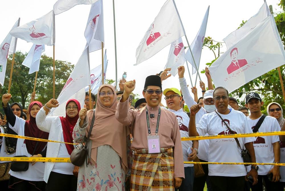 Mohamad Rafie ditemani isteri ketika hadir ke Pusat Penamaan Calon di Kompleks Belia dan Sukan Paroi.