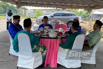 Ahmad Razif (tengah) duduk semeja dengan Khazan menikmati makan pagi di Pusat Penamaan Calon di Dewan Sivik Seberang Takir.