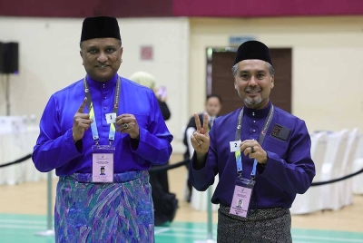 Reezal Marican dan pencabarnya dari Perikatan Nasional Khaliq Mehtab Mohd Ishaq menunjukkan nombor susunan bagi kertas undi sempena proses penamaan calon bagi Pilihan Raya Negeri Pulau Pinang pada Sabtu. - Foto: Bernama 