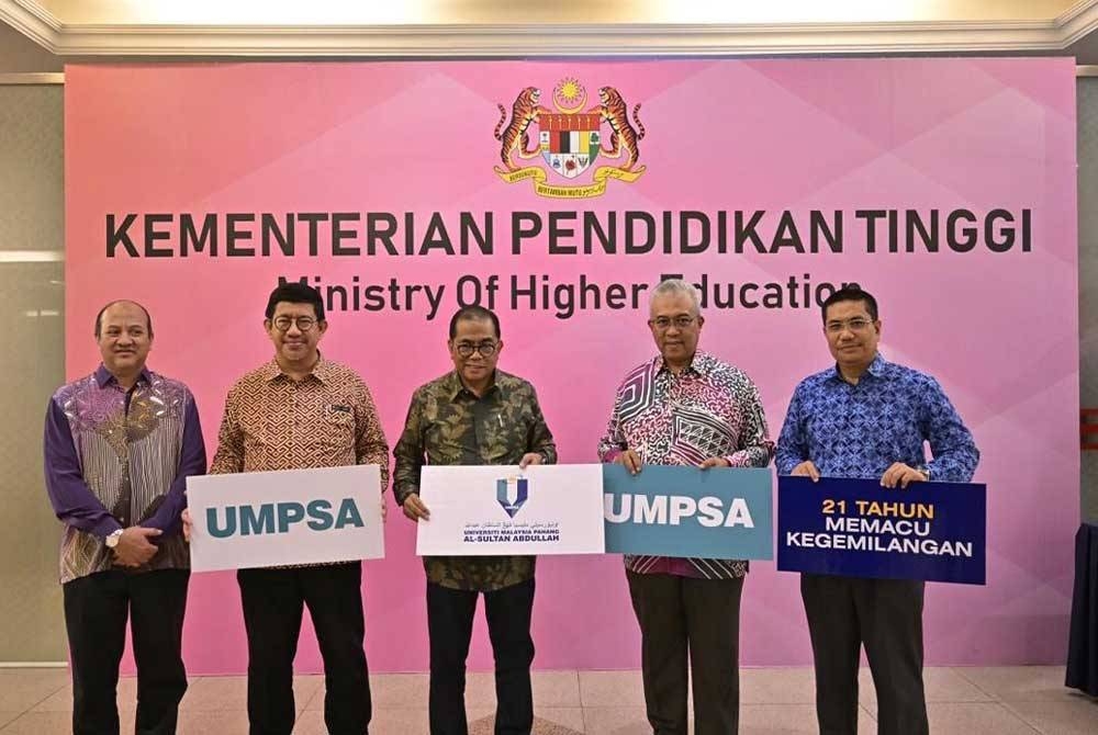 Mohamed Khaled (tengah) dan Yuserrie (dua, kanan) memegang plakad nama dan penjenamaan baharu UMPSA.