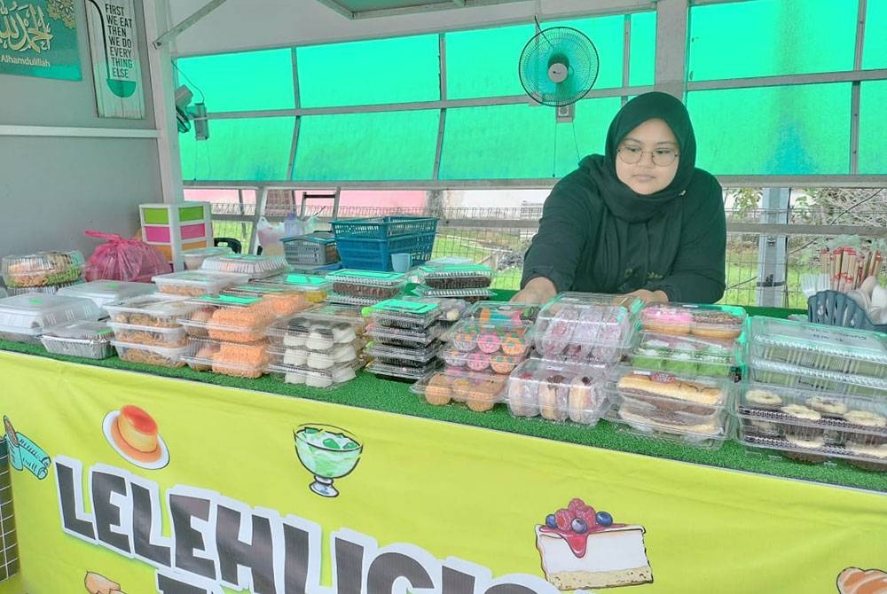 Seorang peniaga sedang menyusun kuih muih yang dijualnya di Laman Niaga Up Town Pandu Lalu berhampiran Hentian Bas Kluang, Kluang.