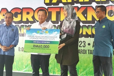Foong Hin (dua dari kiri) menyampaikan replika geran bantuan kepada salah seorang penerima pada Majlis Perasmian Taman Agro Teknologi MARDI Tanjong Karang di sini pada Ahad.