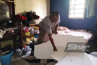 Syed Kamarudin melihat sisa siling yang runtuh.