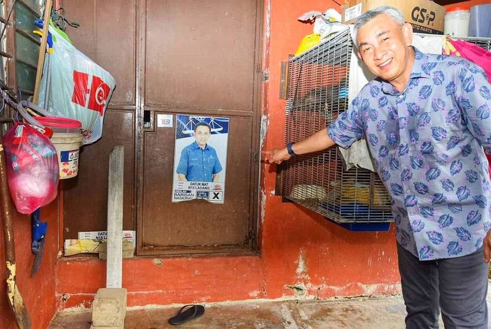 Mohd Sabri menunjukkan poster kempen pada PRU14 lalu yang masih disimpan oleh penghuni sebuah rumah di Kampung Bukit Kecil, Kuala Terengganu.