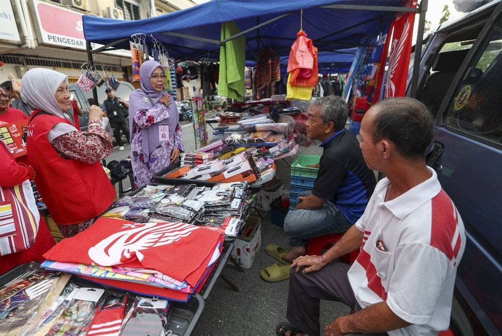 Norwani Ahmat (tiga, kiri) beramah mesra dengan peniaga ketika berkempen di Pasar Malam Senawang Jaya. - Foto Bernama