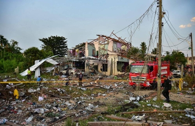 Polis Thailand, kru penyelamat dan penduduk tempatan berkumpul di sekitar rumah yang musnah selepas letupan gudang mercun dan bunga api di Mundok, Sungai Kolok pada Sabtu.- Foto AFP