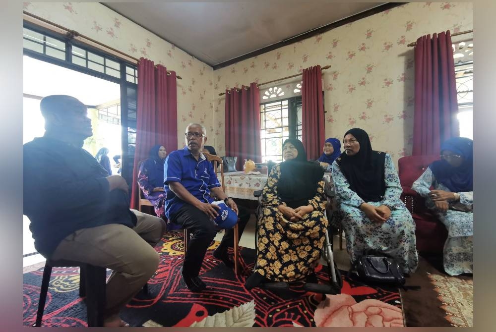 Jalaludin (dua dari kini) menziarahi Azizah di Perumahan Rumah Murah Jalan Pusara di Kuala Berang pada Selasa.