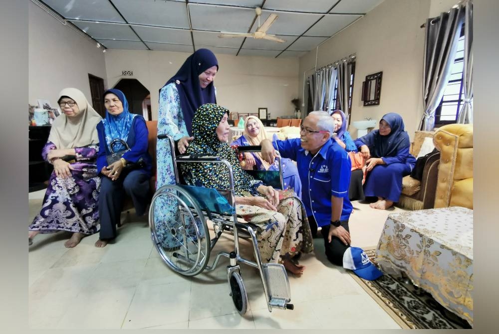 Jalaludin (kanan) ketika mengunjungi Haizan di Kuala Berang, Hulu Terengganu pada Selasa.