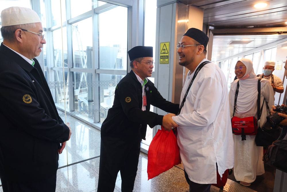 Mohd Na'im (dua dari kiri) bersalaman dengan jemaah haji pada Majlis Sambutan Ketibaan penerbangan akhir jemaah haji Malaysia dari Tanah Suci di KLIA Terminal 1, hari ini. - Foto Bernama