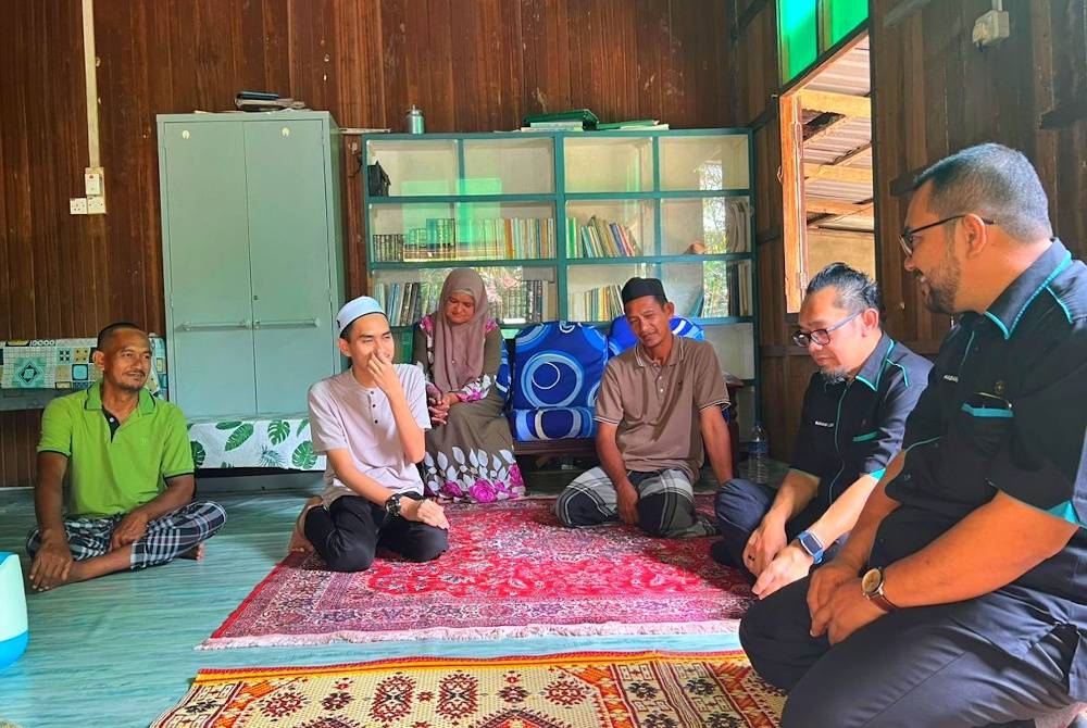 Muhamad Amirul (dua dari kiri) semasa menerima kunjungan wakil daripada Pusat Asasi UIAM untuk membawanya mendaftar pada hari pendaftaran pelajar baharu.