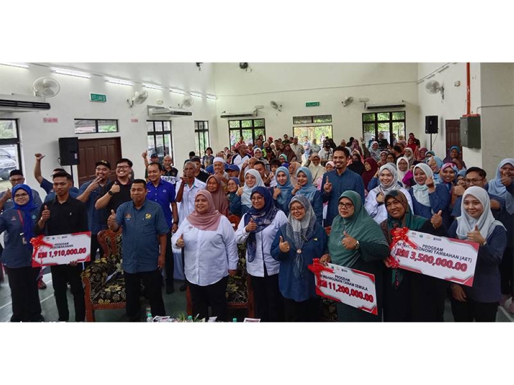 Rubiah (empat dari kiri) bersama-sama para usahawan dan pekebun kecil menunjukkan isyarat bagus semasa Program Pekebun Kecil Makmur Peringkat RISDA Negeri Sembilan di Dewan Serbaguna Kampung Gadong, di sini pada Selasa.