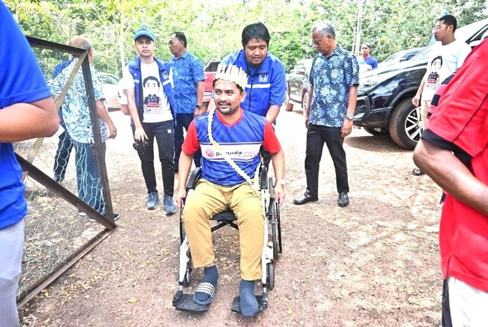 Mohd Zaidy berkerusi roda dibantu jentera parti ketika berkempen.