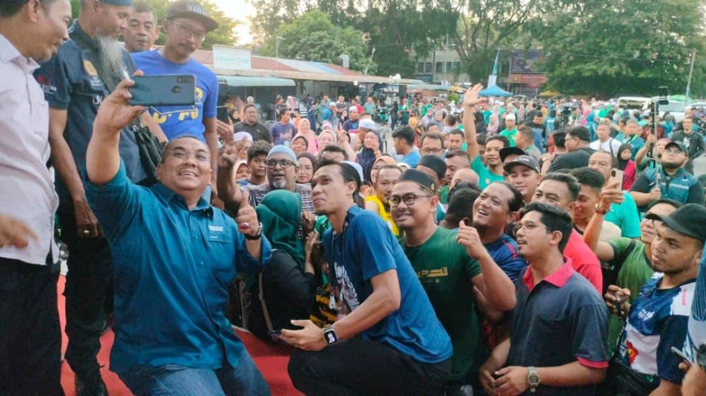 Sanusi dan Baddrol bergambar bersama penyokong yang hadir pada Program Santai Petang bersama Panglima dan Kapten di Medan Gurun jaya pada Khamis.