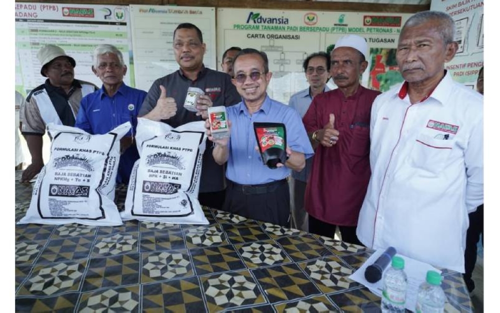 Ahli Jemaah Pengarah NAFAS, Datuk Aimi Jusoh (tiga dari kiri) dan Pengerusi MARDI, Dr Azman Ismail (empat dari kiri) menunjukkan baja serta input pertanian lain sebagai penggalak tambahan bagi projek PTPB di Kampung Nam Dam, Pendang.