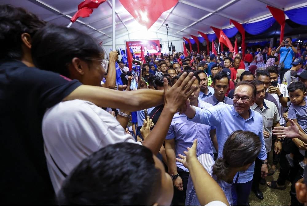 Anwar beramah mesra dengan orang ramai yang hadir pada Majlis Ceramah Jelajah Perpaduan bersama Perdana Menteri di Taman Ampangan pada Rabu. - Foto Bernama