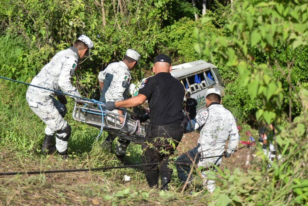 Pasukan penyelamat membantu membawa keluar penumpang bas. - Foto AFP