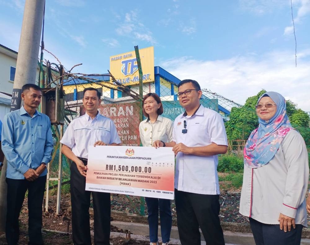 Akmal Nasrullah (dua dari kanan) menyampaikan peruntukan RM1.5 juta bagi pemulihan projek perumahan terbengkalai Taman Mayang Fasa 2, Kuala Kangsar di bawah Inisiatif Belanjawan 2023.