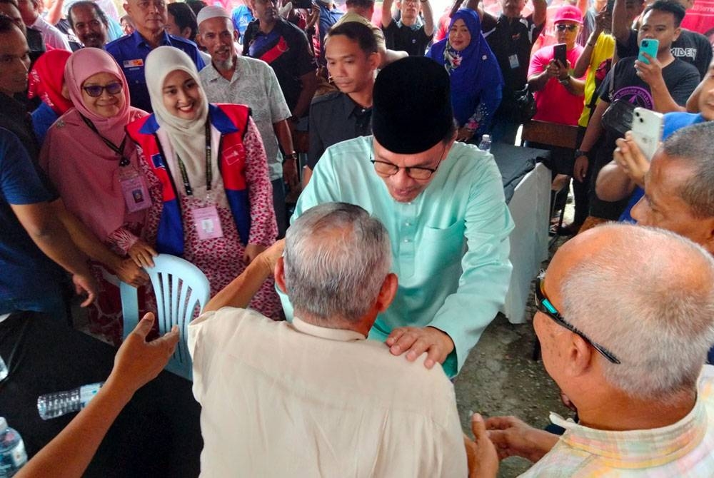 Erni Afrishah (dua dari kiri) dan Mariam (kiri sekali) mengiringi Perdana Menteri bertemu rakyat di Bukit Kapar.