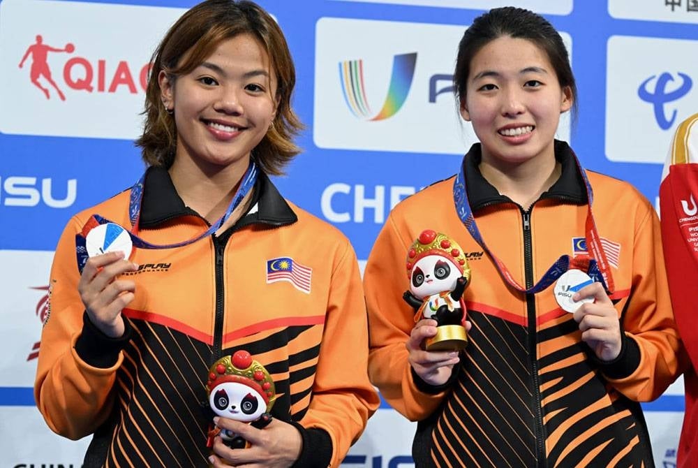 Kimberly (kiri) dan Ker Ying menyumbang pingat perak dalam acara 3m papan anjal seirima.