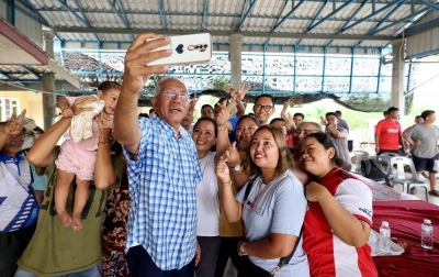 Mahdzir (tengah) merakamkan swafoto bersama penduduk ketika kempen di Pedu, di sini, pada Khamis.