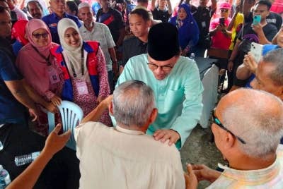 Erni Afrishah (dua dari kiri) dan Mariam (kiri sekali) mengiringi Perdana Menteri bertemu rakyat di Bukit Kapar.