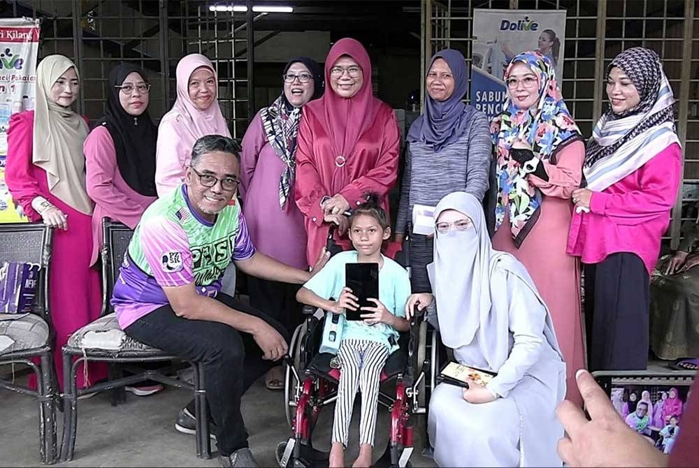 Zaki (duduk, kiri) bersama Dhia (tengah) ketika mengadakan ziarah di rumah kanak-kanak berusia sembilan tahun itu di rumahnya di Sungai Lembing di sini pada Sabtu.